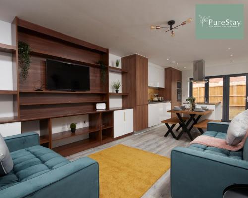 a living room with two blue couches and a tv at Stunning 5 Bed House By PureStay Short Lets & Serviced Accommodation Manchester With Parking in Manchester