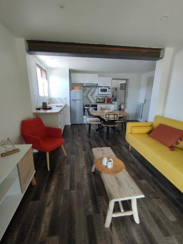 un salon avec un canapé jaune et une table dans l'établissement Entre Lacs et Montagnes, à Cusy