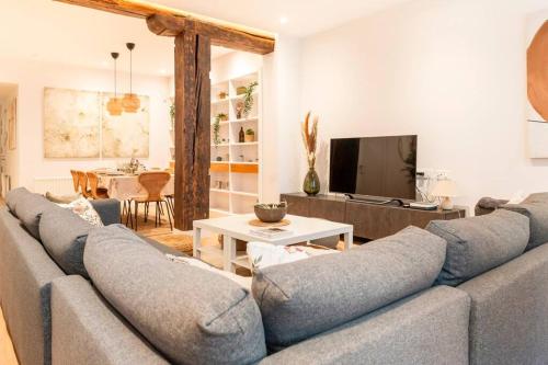 - un salon avec un canapé et une télévision dans l'établissement OT Residence 5 bedrooms 4 bathrooms luxury apartment in Old Town, à Bilbao