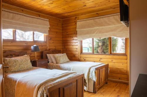 a bedroom with two beds in a log cabin at New Holme Nature Lodge in Hanover Road