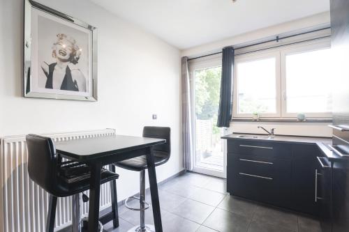 cocina con mesa y fregadero en Les Figuiers - Appartement Cozy avec Jardin, en Andenne
