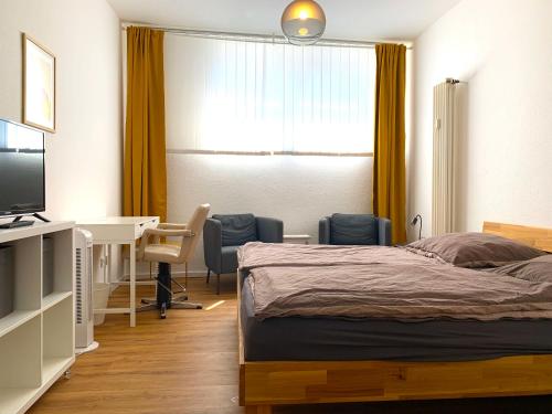 una camera con letto, scrivania e tavolo di Alles komplett: Zwei Schlafzimmer, große Küche, eigenes Bad a Colonia