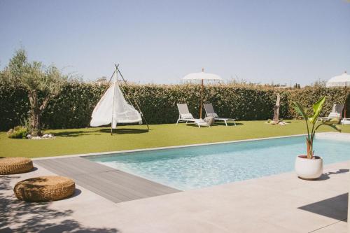 a swimming pool in a yard with two chairs and a tent at Casa L-N-Noa Boutique room whit private pool in Lagos