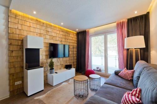 ein Wohnzimmer mit einem Sofa und einem TV in der Unterkunft Auerhahn Feldberg in Feldberg