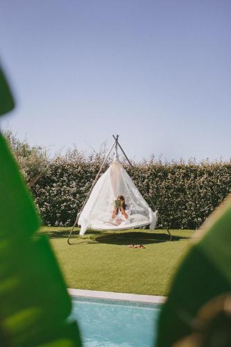 a woman laying in a hammock next to a pool at Casa LNNoa Boutique Room whit private pool in Lagos