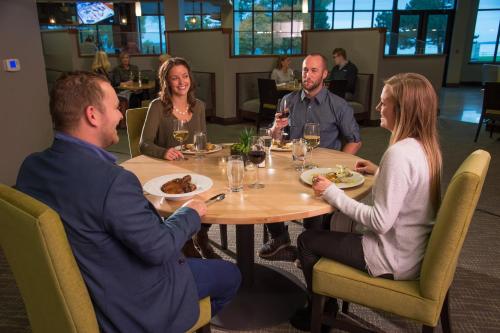 a group of people sitting around a table in a restaurant at Hotel Indigo Traverse City by IHG in Traverse City