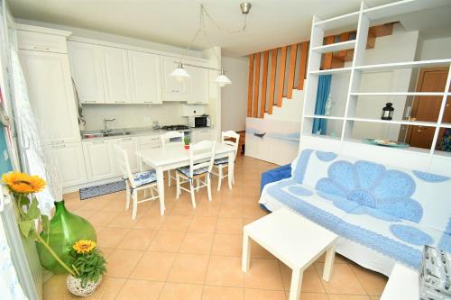 a kitchen and a living room with a table and chairs at Appartamenti Arcobaleno in Casa Bullo