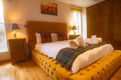 sypialnia z dużym łóżkiem i żółtą ławką w obiekcie Luxury Cottage With Stunning Views Near Fairy Pools! w mieście Carbost
