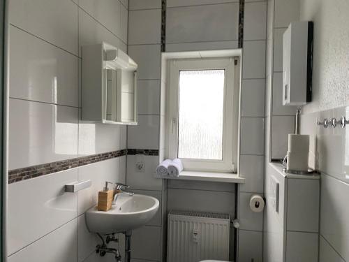ein Bad mit einem Waschbecken, einem WC und einem Fenster in der Unterkunft Lux Apartment near Frankfurt! in Mörfelden-Walldorf