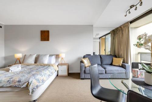 a bedroom with a bed and a couch at Studio in Hyde park, best location in Sydney City in Sydney