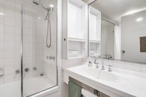 La salle de bains blanche est pourvue d'un lavabo et d'une douche. dans l'établissement Studio in Hyde park, best location in Sydney City, à Sydney