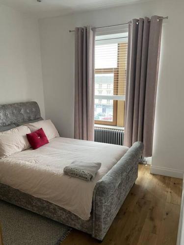 a bed sitting in a room with a window at Top Floor Flat - Glasgow West End - Partick in Glasgow