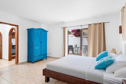 a bedroom with a blue cabinet and a bed at Villa Munay in Puerto del Carmen