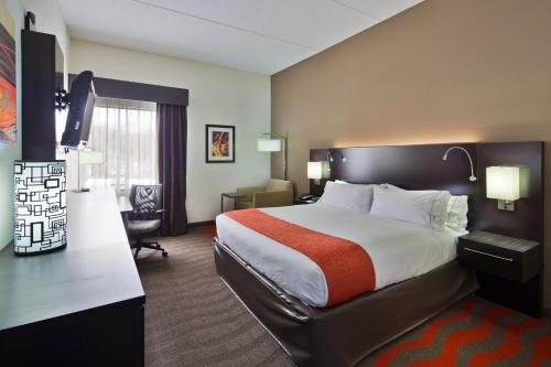 Habitación de hotel con cama grande y escritorio. en Holiday Inn Express Harrisburg NE, an IHG Hotel, en Manadahill