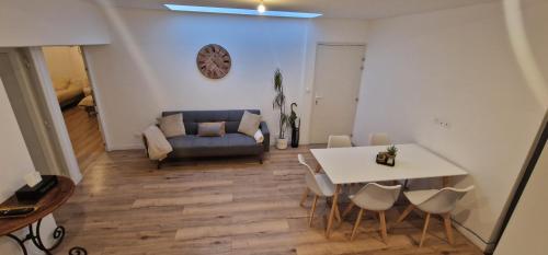 un salon avec un canapé, une table et des chaises dans l'établissement Appartement cosy près de Douai, à Flers-en-Escrebieux