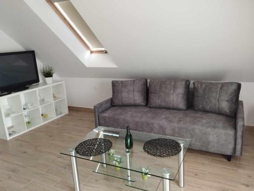 uma sala de estar com um sofá e uma mesa de vidro em Apartment/mieszkanie u Janusza em Grybów