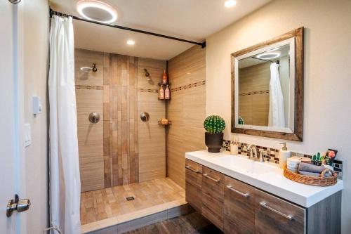 a bathroom with a shower and a sink and a mirror at Home on camano in Camano
