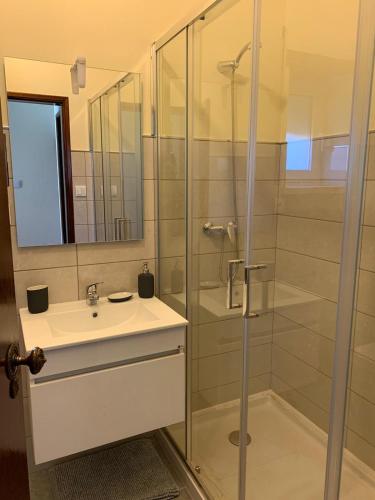 a bathroom with a glass shower and a sink at Casa da Fonte in Seia