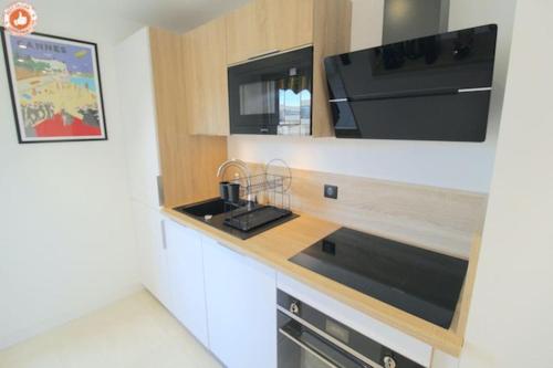 une cuisine avec un comptoir avec un évier et un micro-ondes dans l'établissement ALC - BR12 - 3 min Croisette - 14 min Palais, à Cannes