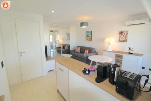 une cuisine et un salon avec un canapé et une table dans l'établissement ALC - BR12 - 3 min Croisette - 14 min Palais, à Cannes