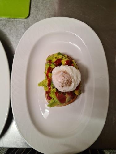 een wit bord met een donut met een ei erop bij Christleton House in Llandudno