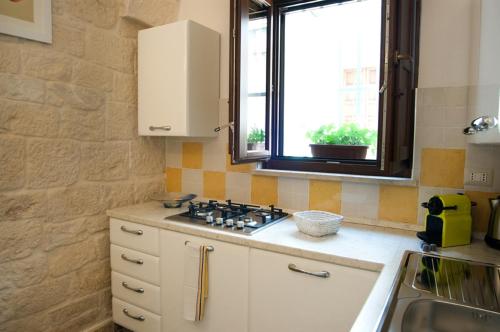 a kitchen with a stove and a window in it at Apartment Mammacara in Ceglie Messapica
