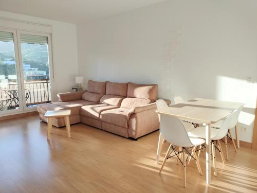 ein Wohnzimmer mit einem Sofa und einem Tisch in der Unterkunft Apartamento PATXIKE con plaza de garaje in Bermeo