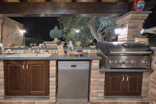 a outdoor kitchen with a stove and a sink at Villa Alecla - Sea Villa near Taormina in SantʼAlessio Siculo