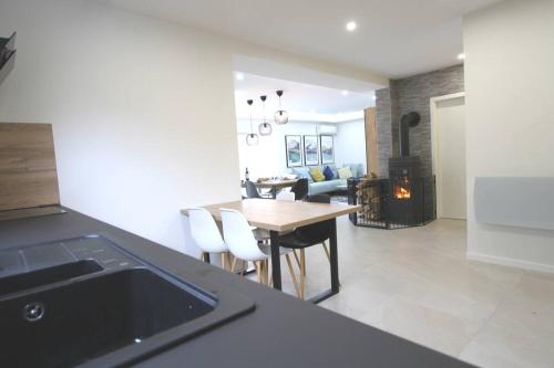 une cuisine et un salon avec une table et des chaises dans l'établissement Maison cossue, moderne et calme à La Bresse 5 chbr, à La Bresse