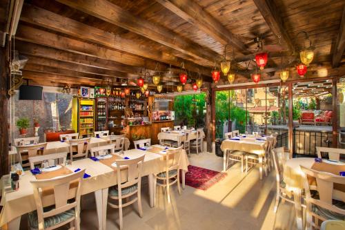 - un restaurant avec des tables et des chaises dans une salle dans l'établissement Cappadocia Fairy Chimneys Selfie Cave Hotels - Special Class, à Uçhisar