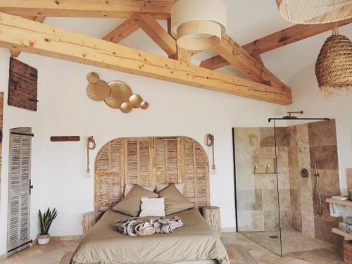 1 dormitorio con cama y techo de madera en LE CABANON 2.42, en Le Thor