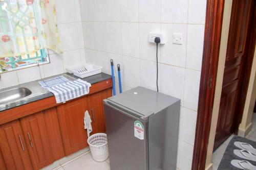 Elle comprend une petite cuisine équipée d'un réfrigérateur et d'un évier. dans l'établissement Pacho Studio-2, à Kisumu