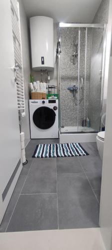 a bathroom with a shower and a white stove at Sova studio apartment Bjelasnica in Bjelašnica