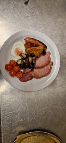 a plate of breakfast food with eggs sausage and toast at Christleton House in Llandudno