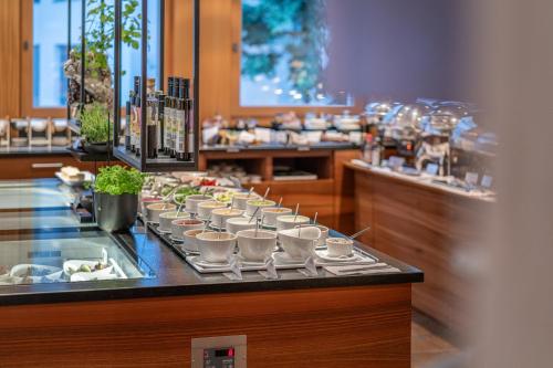 a buffet line with cups and plates of food at hirschen dornbirn - das boutiquestyle hotel - skyrelax & wellness im rooftop in Dornbirn