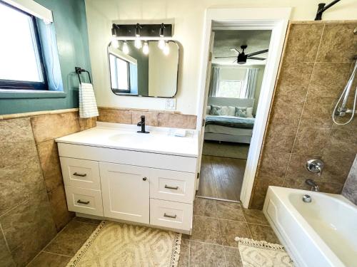 羅德岱堡的住宿－Bougainvilla Seaside Suites，一间带水槽、浴缸和镜子的浴室
