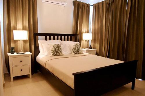 a bedroom with a large bed with two night stands at Lovely condo at Blue Sea Tower near Juan Dolio beach in Juan Pedro