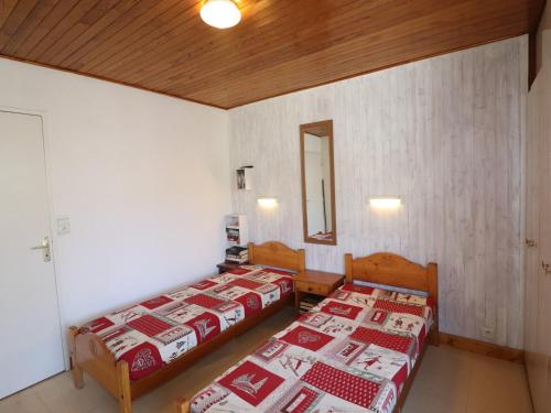 Cette chambre comprend 2 lits et un miroir. dans l'établissement Tignes - Appartement 2 pièces, 37m², 5 pers, ski aux pieds, balcon, WiFi, parking options - FR-1-502-532, à Tignes
