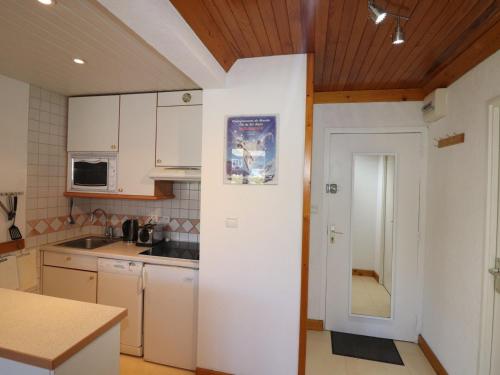 une cuisine avec des placards blancs et une porte menant à une chambre dans l'établissement Tignes - Appartement 2 pièces, 37m², 5 pers, ski aux pieds, balcon, WiFi, parking options - FR-1-502-532, à Tignes