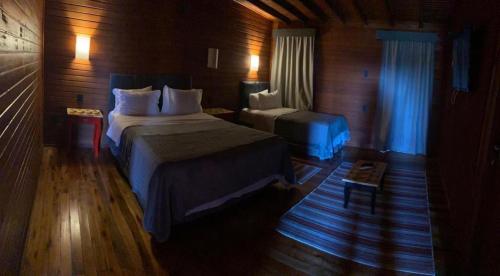 a hotel room with a bed and a table at Vinícola D'alture - Cabana Familiar in São Joaquim