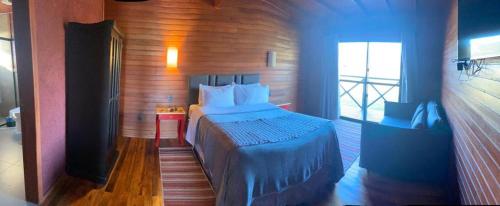 1 dormitorio con 1 cama grande en una habitación en Vinícola D'alture - Cabana Familiar, en São Joaquim