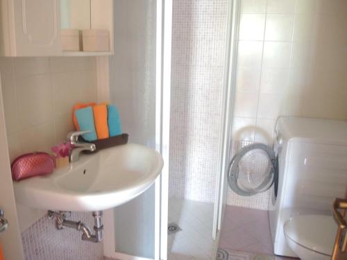 een witte badkamer met een wastafel en een douche bij Comfy&cozy flat next to the beach - Beahost in Bibione