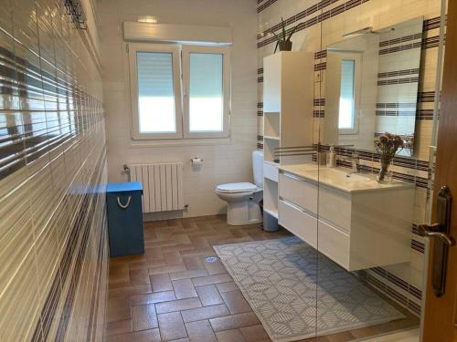 een badkamer met een toilet, een wastafel en een raam bij HyP - Casa Chalo in Sotomayor