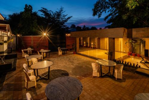 a patio with tables and chairs at night at THE VENUE by Seasons Suites in Dod Ballāpur