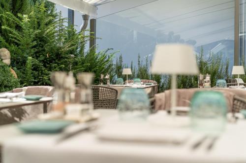 a restaurant with tables and chairs with a view of the mountains at hirschen dornbirn - das boutiquestyle hotel - skyrelax & wellness im rooftop in Dornbirn