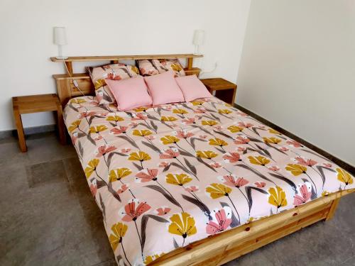 a bedroom with a bed with a floral bedspread at Chambre d'hôte in Grabels