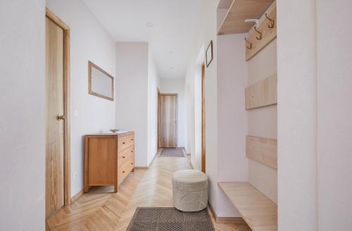 - un couloir d'une maison dotée de murs blancs et de parquet dans l'établissement Old Town apartment, à Kaunas