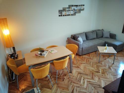ein Wohnzimmer mit einem Tisch, Stühlen und einem Sofa in der Unterkunft Kuća za odmor Vidikovac in Bajina Bašta