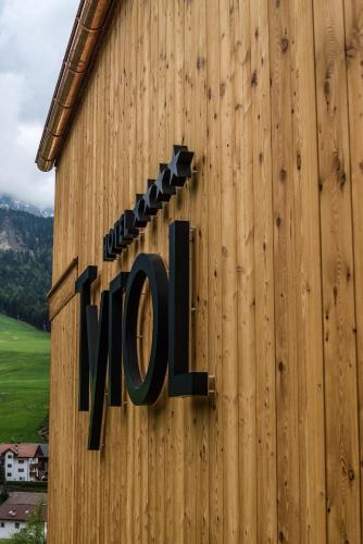 a sign on the side of a building with the word zoo at Hotel Tyrol in Funes