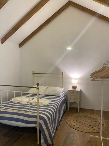 a bedroom with a bed and a white wall at Monte da Venda de Baixo in Santa Margarida da Serra